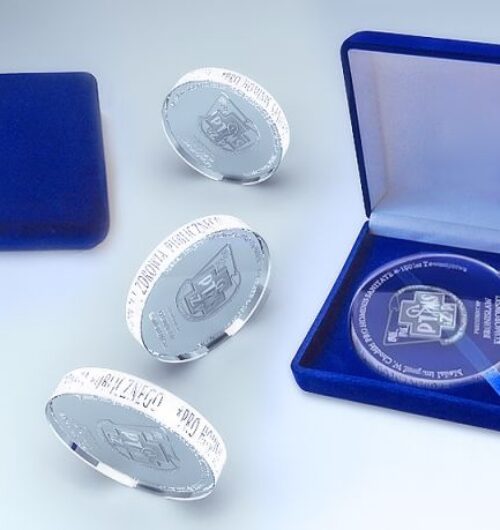 Kryształowy medal na specjalne okazje w niebieskim opakowaniu.