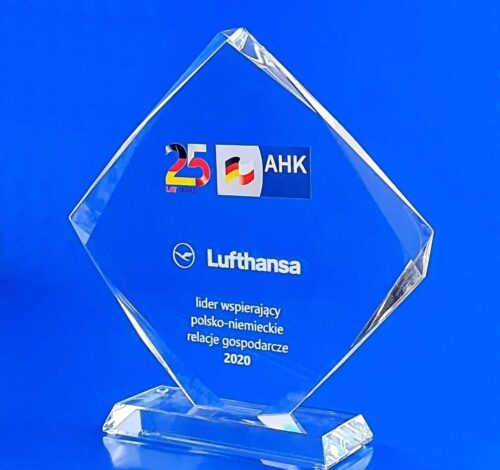 statuetka szklana z okazji 25-lecia AHK, statuetka szklana w kształcie rombu z dekoracyjnymi szlifami na szklanej trapezowej podstawce, jubileuszowe logo jako nadruk UV, dedykacja jako grawer 3d, szklany prezent na jubileusz firmy
