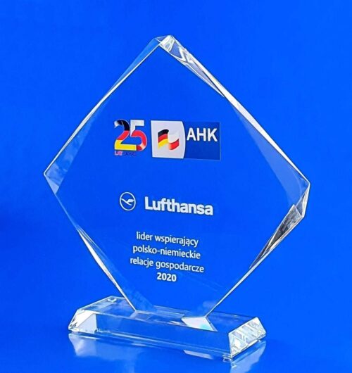 statuetka szklana z okazji 25-lecia AHK, statuetka szklana w kształcie rombu z dekoracyjnymi szlifami na szklanej trapezowej podstawce, jubileuszowe logo jako nadruk UV, dedykacja jako grawer 3d, szklany prezent na jubileusz firmy