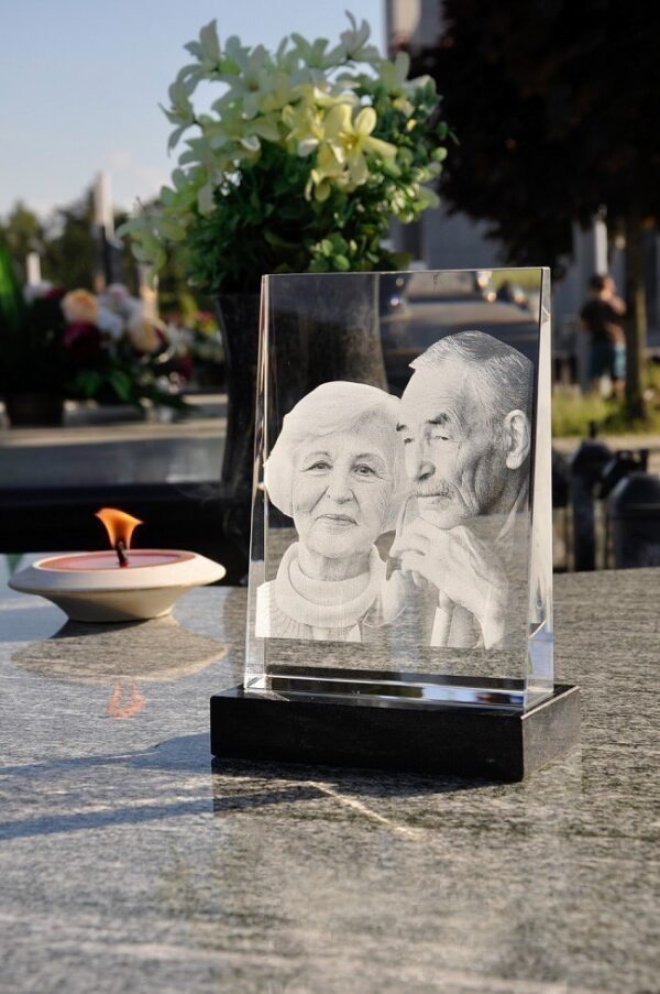 zdjęcia w krysztale na pomnik, zdjęcia dwóch osób wygrawerowane wewnątrz szkła, kryształ ze zdjęciem umieszczony na kamiennej podstawce, którą można przykleić do płyty pomnika