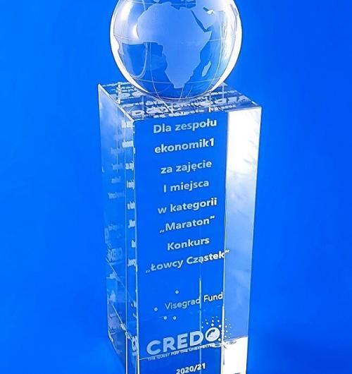 statuetka szklany globus nagroda dla łowców cząstek. Szklana nagroda z globusem dla uczestników konkursu Instytutu Fizyki Jądrowej. Kryształowy prostopadłościan z globusem z grawerem 3d, Statuetka 3d, Kryształ 3D z grawerem