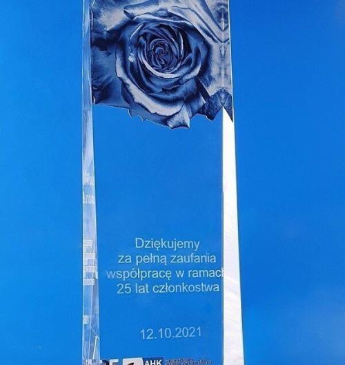 elegancka szklana statuetka zwężająca się ku górze, jubileuszowa róża jako nadruk UV, podziękowanie za współpracę grawerowane laserem 3D statuetka róża podziękowanie za współpracę nadruk grawer 3D