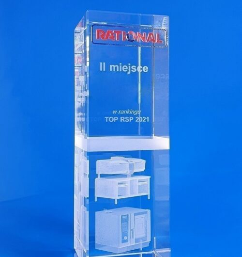 szklana nagroda sprzedawca roku firmy Rational. Kryształowy prostopadłościan z grawerowanym modelem urządzenia gastronomicznego w 3D Logo Rational piaskowane i malowane w kolorze niebieskim i czerwonym Unikatowa statuetka na zamówienie, która łączy trzy techniki zdobienia szkła grawerowanie 3D, piaskowanie oraz malowanie natryskowe Wszechstronne urządzenie do restauracji jako model 3D bardzo precyzyjnie wygrawerowane w bryle szkła kryształowego
