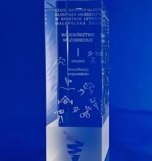 szklana statuetka na Olimpiadę, sportowe ikony grawerowane 3D wewnątrz kryształowej bryły. Logo Olimpiady piaskowane na szkle, kryształowe trofeum na zakończenie Olimpiady Młodzieży w sportach letnich w 2022