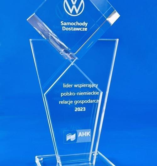 szklana statuetka okolicznościowa Volkswagen, szklana nagroda dla lidera biznesu polsko-niemieckiego od AHK W kryształowej bryle wygrawerowane w 3D logo Volkswagen Samochody Dostawcze Dedykacja grawerowana laserem 3D wewnątrz szkła Kryształowa statuetka klasy premium na wyjątkowe okazje