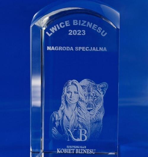 szklane statuetki Lwice Biznesu, zdjęcie eleganckiej kobiety obok lwicy wygrawerowane laserem 3D. Statuetki personalizowane z logo konkursu. Prestiżowa szklana nagroda Europejskiego Klubu Kobiet Biznesu