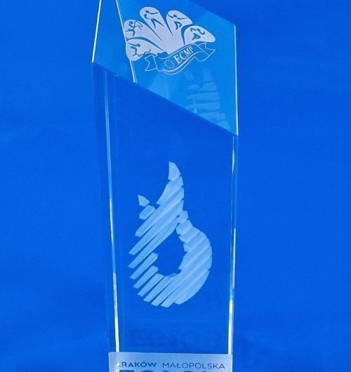 szklana statuetka sportowa European Games Kraków, bardzo efektowna kryształowa statuetka z okazji Igrzysk Europejskich Prestiżowa statuetka z efektownym ścięciem, na którym umieszczone jest logo Kryształowe trofeum sportowe z grawerem 3D Statuetka łączy 2 techniki zdobienia – grawerowanie 3D oraz głębokie piaskowanie na szkle