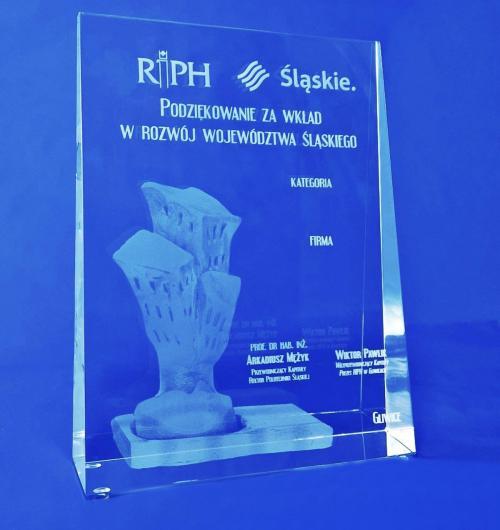 szklana statuetka okolicznościowa na konkurs Marka Śląskie, rzeźba budynków wygrawerowana w 3D wewnątrz szkła kryształowego Piękne, duże szkło kryształowe, delikatnie zwężające się ku górze Kryształowa statuetka podziękowanie za wkład w rozwój województwa śląskiego