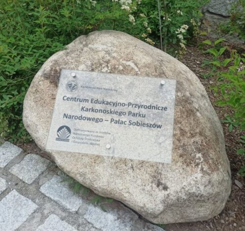 szklana tablica pamiątkowa dla Centrum Przyrodniczo-Edukacyjnego Karkonoskiego Parku Narodowego Szklana tablica pamiątkowa umieszczona na kamieniu znajdującym się na terenie Pałacu w Sobieszowie