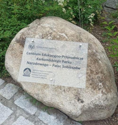 szklana tablica pamiątkowa dla Centrum Przyrodniczo-Edukacyjnego Karkonoskiego Parku Narodowego Szklana tablica pamiątkowa umieszczona na kamieniu znajdującym się na terenie Pałacu w Sobieszowie