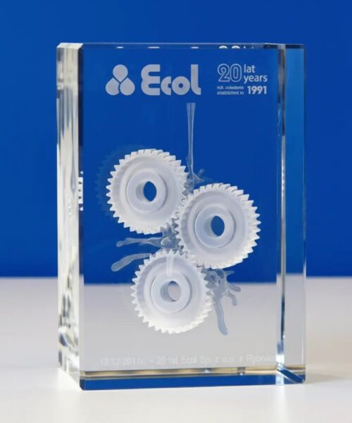 szklana statuetka jubileuszowa z okazji 20-lecia działalności firmy Ecol, statuetka w kształcie kryształowego prostopadłościanu, w którym wygrawerowaliśmy zębatki w 3D jako symbol upominków biznesowych z okazji jubileuszu statuetka wykonana przez polskiego producenta – Laser 3D Zielona Góra, jako pierwsi w Polsce wprowadziliśmy grawerowanie 3D w szkle już ponad 25 lat temu